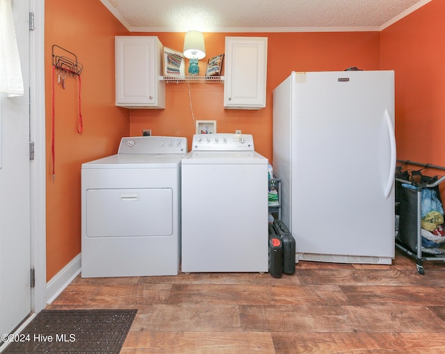 clothes washing area featuring cabinets, ornamental molding, dark wood-type flooring, and independent washer and dryer