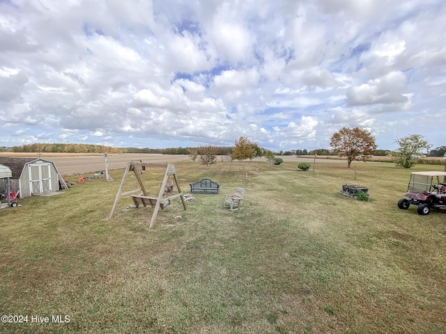 view of yard featuring a rural view and a storage shed