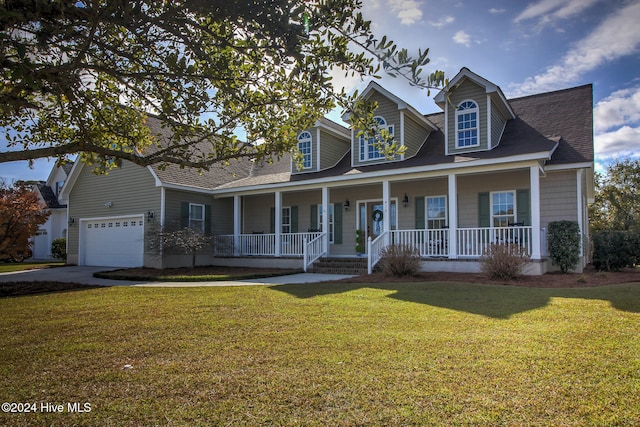 new england style home featuring a porch, a garage, and a front yard