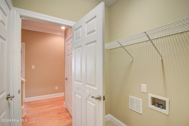 clothes washing area with washer hookup, electric dryer hookup, and light wood-type flooring