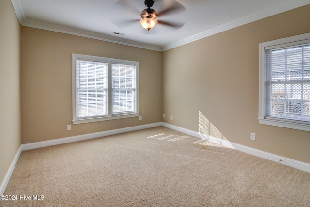 empty room featuring ceiling fan, light carpet, and ornamental molding