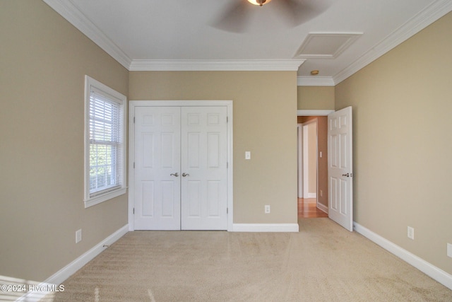 unfurnished bedroom with ceiling fan, a closet, light colored carpet, and ornamental molding