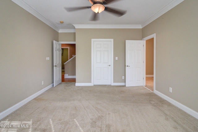 unfurnished bedroom featuring light colored carpet, ceiling fan, and crown molding