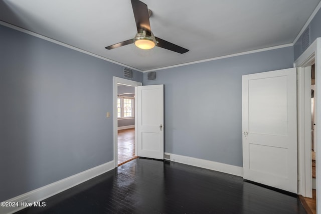 empty room featuring dark hardwood / wood-style floors, crown molding, and ceiling fan