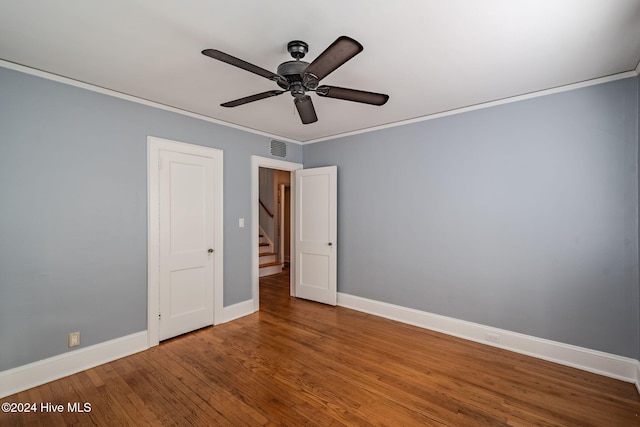 unfurnished bedroom with hardwood / wood-style floors, ceiling fan, and crown molding