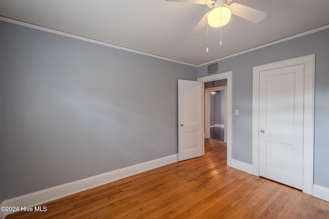 unfurnished bedroom featuring light wood-type flooring, ceiling fan, and crown molding