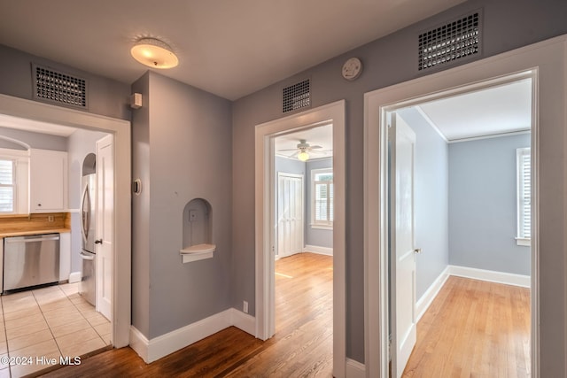 hall with plenty of natural light and light hardwood / wood-style flooring