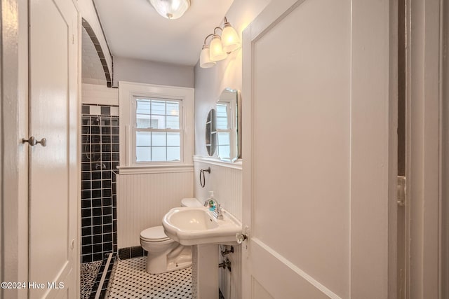 bathroom featuring toilet, sink, and tile patterned flooring