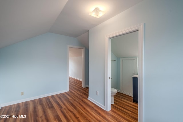 additional living space featuring vaulted ceiling and dark hardwood / wood-style flooring