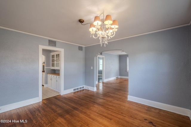 interior space featuring a chandelier, light hardwood / wood-style floors, and crown molding