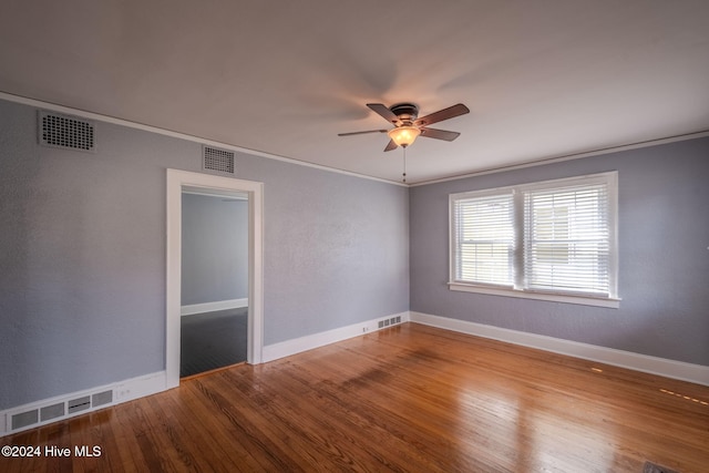 spare room featuring hardwood / wood-style flooring, ceiling fan, and ornamental molding