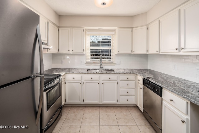 kitchen featuring white cabinets, stainless steel appliances, a sink, and light tile patterned flooring