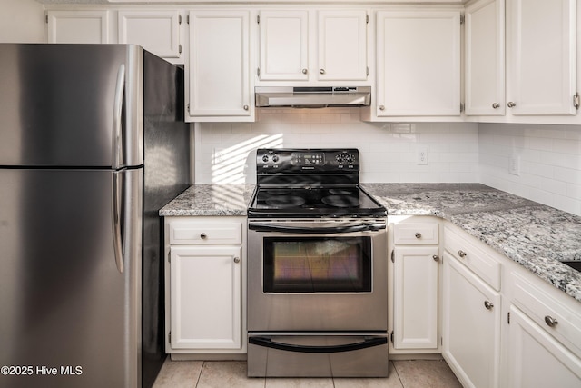 kitchen featuring light tile patterned floors, light stone counters, under cabinet range hood, white cabinets, and appliances with stainless steel finishes