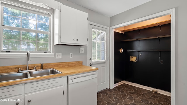 kitchen featuring dishwasher, white cabinetry, sink, and dark tile patterned floors