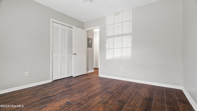 unfurnished bedroom with dark hardwood / wood-style floors and a closet