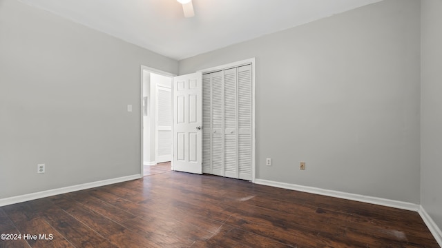 unfurnished bedroom with ceiling fan, dark hardwood / wood-style floors, and a closet