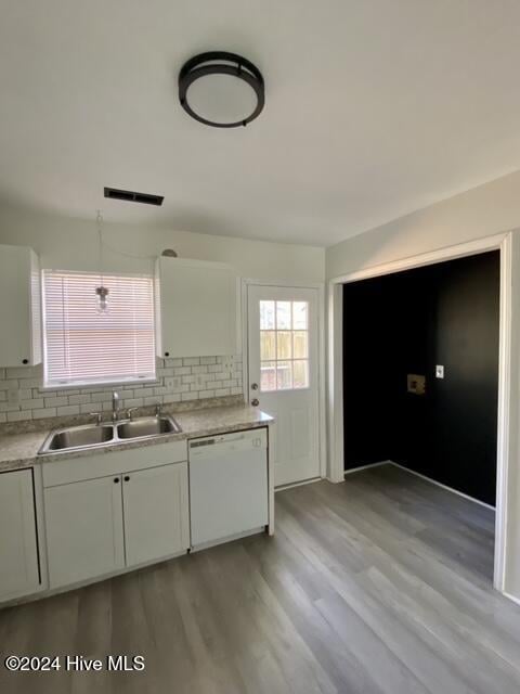 kitchen featuring light hardwood / wood-style floors, dishwasher, decorative backsplash, white cabinets, and sink