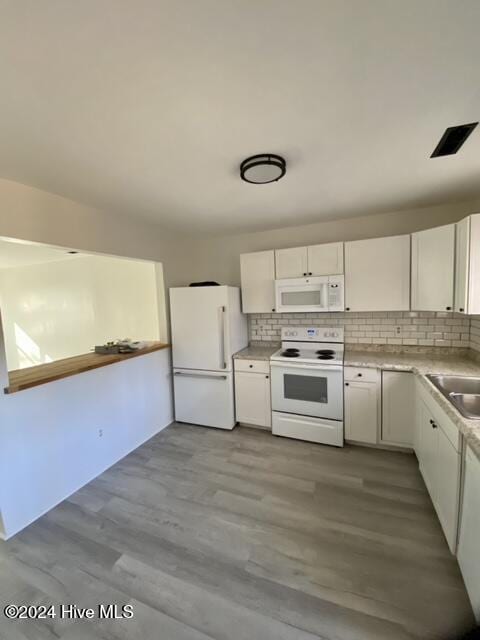 kitchen featuring light hardwood / wood-style floors, white cabinetry, sink, white appliances, and decorative backsplash