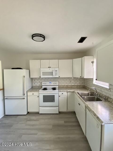 kitchen with white cabinetry, decorative backsplash, sink, light hardwood / wood-style floors, and white appliances