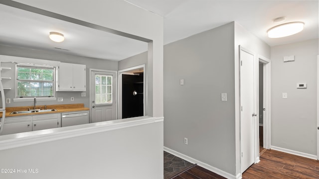 kitchen featuring dark wood-type flooring, white cabinets, sink, and dishwasher