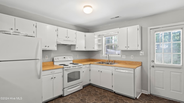 kitchen featuring white cabinetry, plenty of natural light, and white appliances