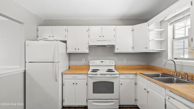 kitchen with white appliances, white cabinetry, and sink