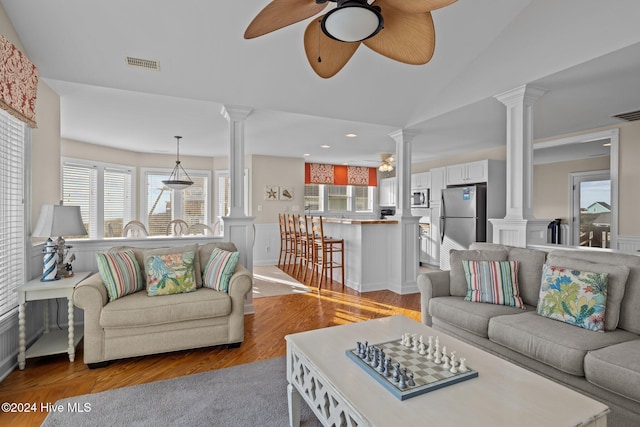 living room with vaulted ceiling, ceiling fan, and light hardwood / wood-style flooring