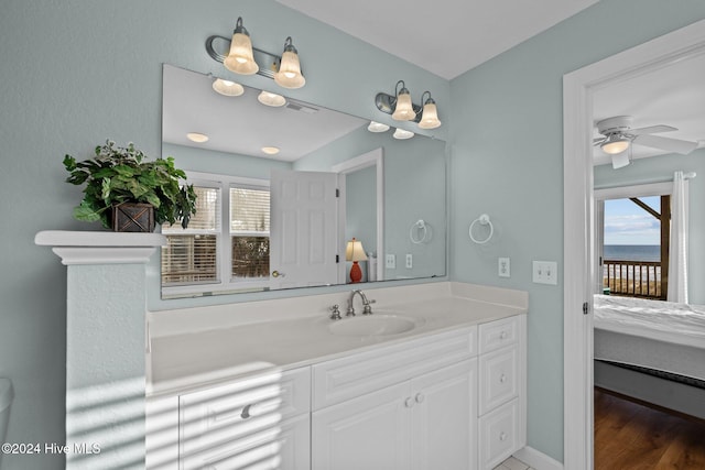 bathroom with vanity, hardwood / wood-style floors, a water view, and ceiling fan with notable chandelier