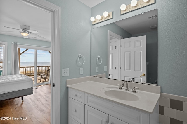 bathroom featuring a water view, ceiling fan, vanity, and wood-type flooring