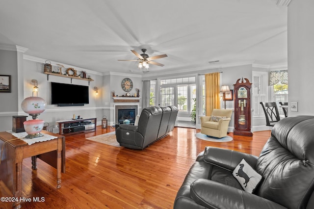 living room featuring a wealth of natural light, ceiling fan, crown molding, and hardwood / wood-style flooring