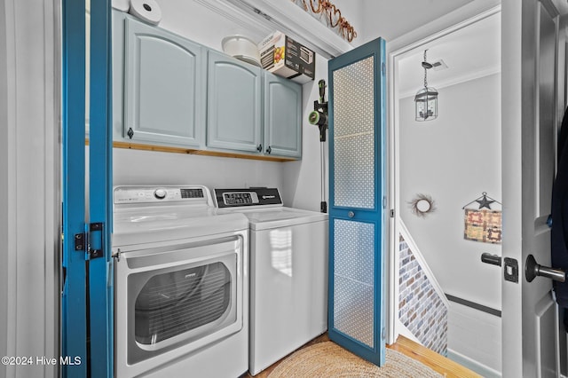 laundry room featuring cabinets, washing machine and dryer, and crown molding