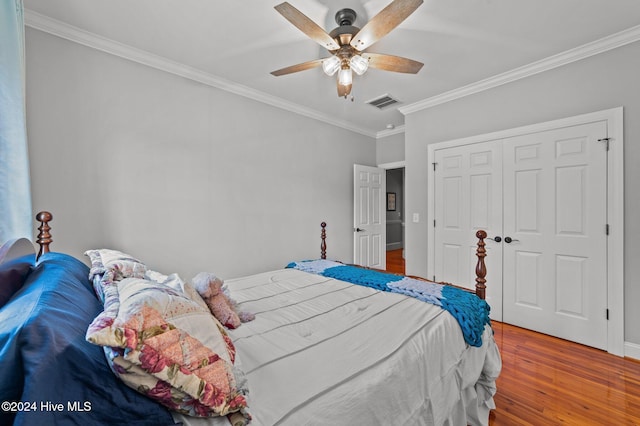 bedroom featuring hardwood / wood-style flooring, ceiling fan, crown molding, and a closet