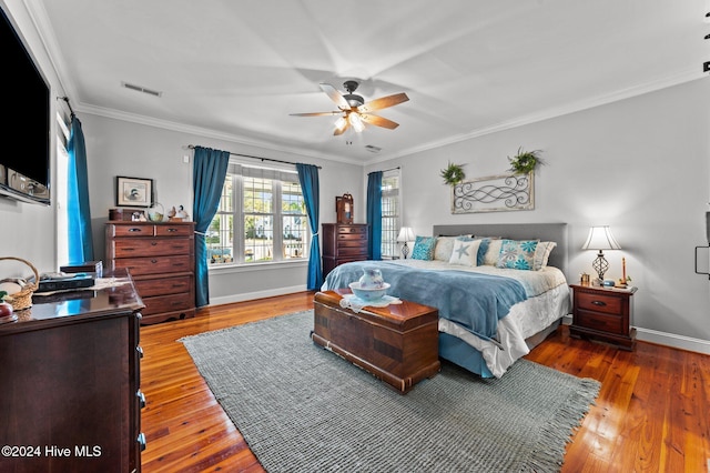 bedroom with hardwood / wood-style floors, ceiling fan, and crown molding