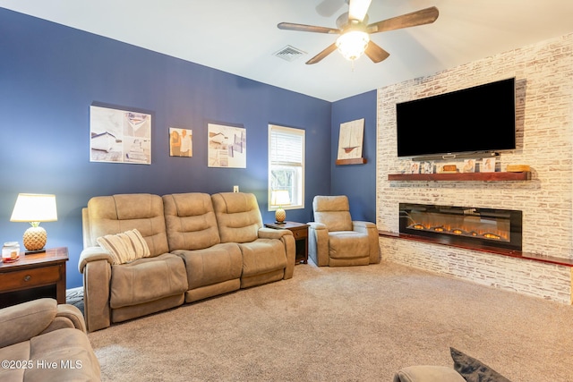 carpeted living room featuring ceiling fan and a fireplace