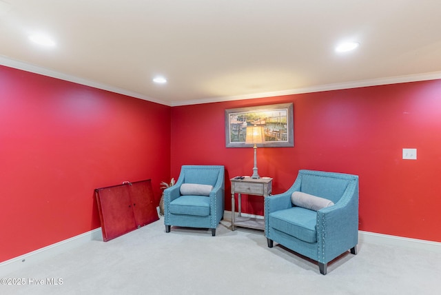 sitting room featuring ornamental molding and carpet flooring