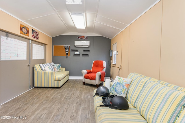 living room with vaulted ceiling, an AC wall unit, and hardwood / wood-style floors