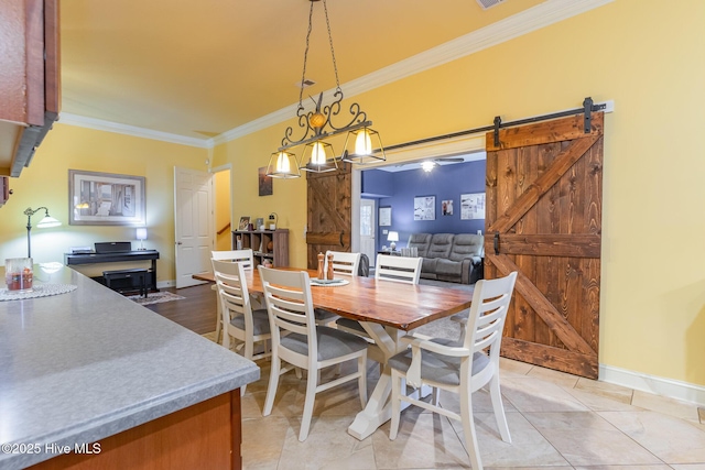 dining space featuring crown molding, a barn door, and light tile patterned floors