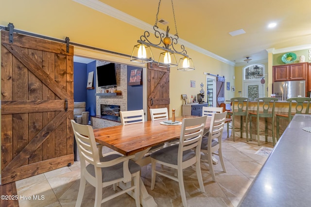 tiled dining space featuring crown molding and a barn door