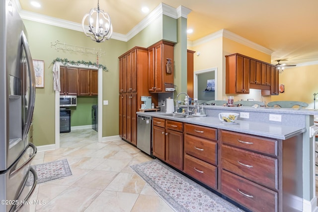 kitchen featuring sink, decorative light fixtures, ornamental molding, and appliances with stainless steel finishes