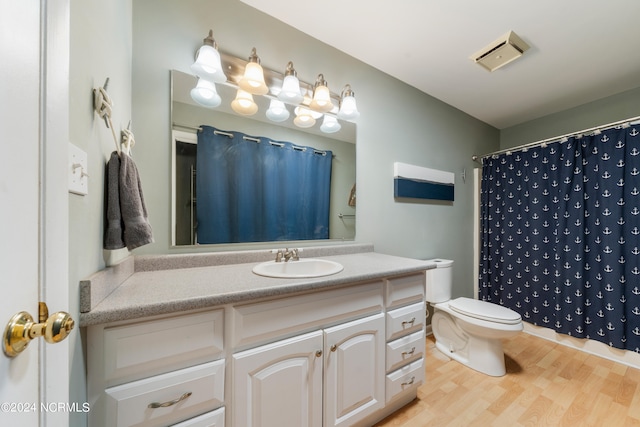 bathroom with wood-type flooring, vanity, curtained shower, and toilet