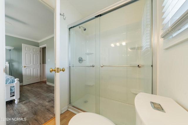 bathroom featuring walk in shower, wood-type flooring, ornamental molding, and toilet