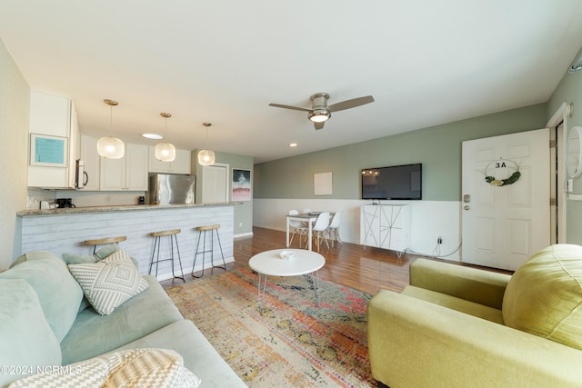 living room featuring hardwood / wood-style floors and ceiling fan