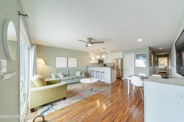 living room with dark hardwood / wood-style flooring and ceiling fan