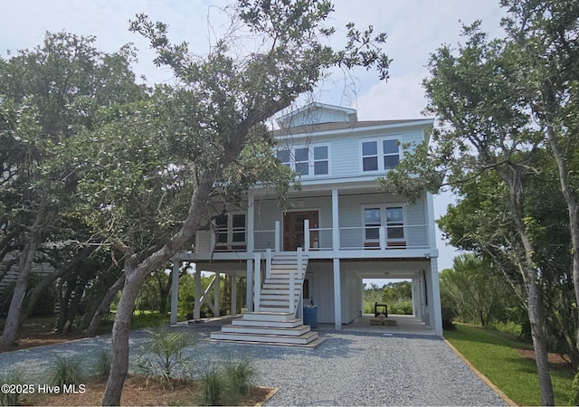 109 Old Village Ln, North Topsail Beach, NC 28460 - coastal inspired home featuring a carport, covered porch, driveway, and stairs