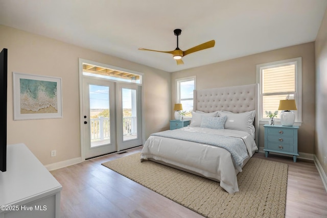 bedroom featuring access to exterior, multiple windows, baseboards, and light wood-style floors