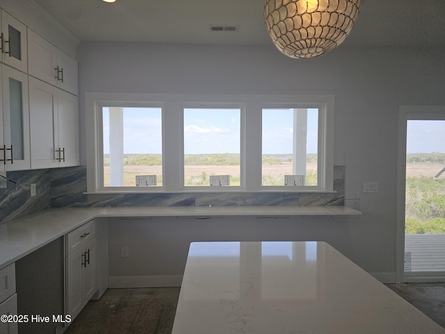 109 Old Village Ln, North Topsail Beach, NC 28460 - kitchen featuring plenty of natural light, backsplash, white cabinets, and light stone countertops