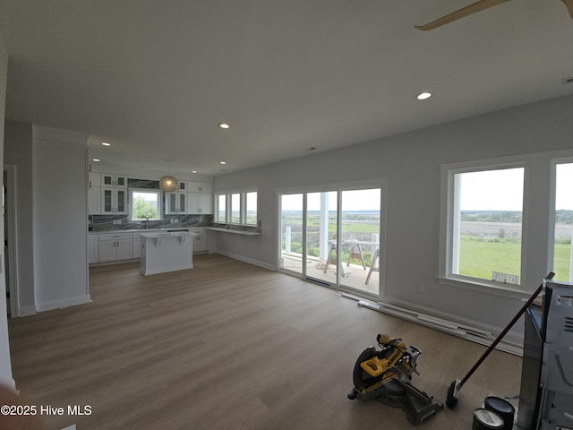 109 Old Village Ln, North Topsail Beach, NC 28460 - unfurnished living room with recessed lighting, light wood-type flooring, a sink, baseboards, and ceiling fan
