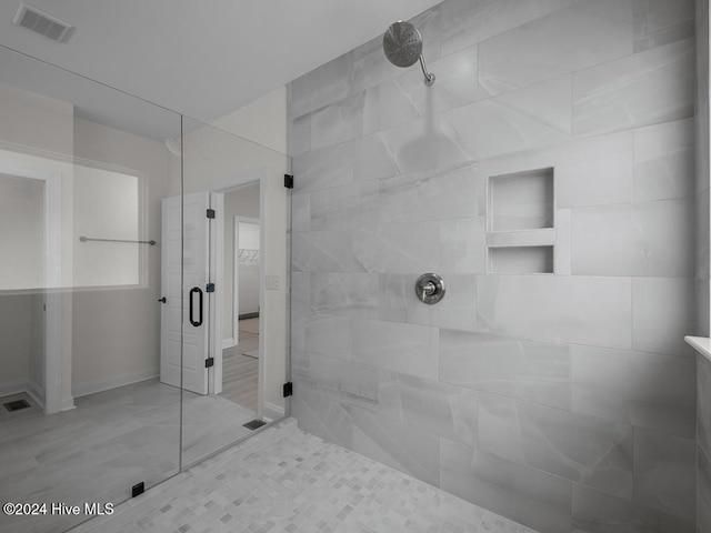 bathroom with visible vents and a tile shower