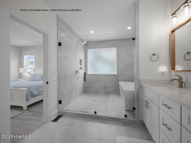 full bathroom featuring a freestanding tub, recessed lighting, vanity, a stall shower, and ensuite bath