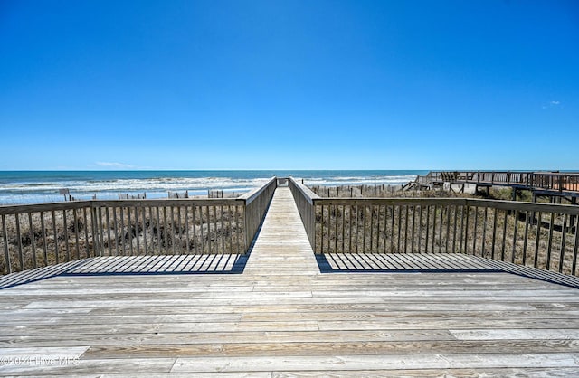 view of property's community with a water view and a beach view